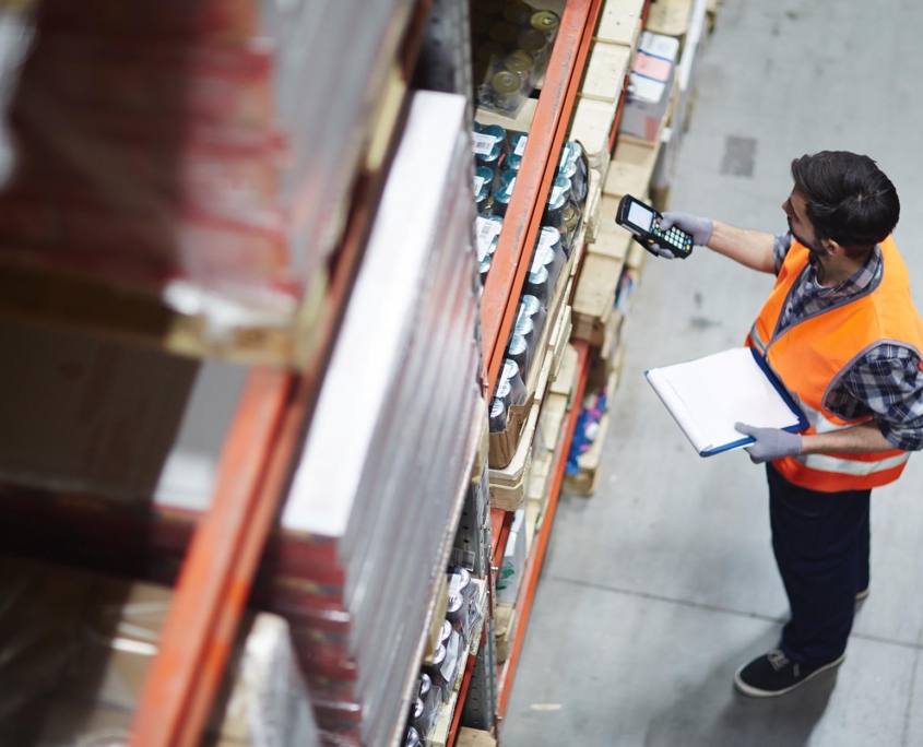 Worker scanning items on shelves in warehouse