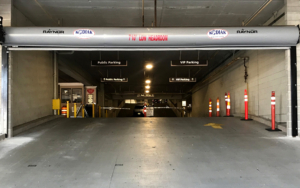 Automated parking garage gate with security sensors and signage.